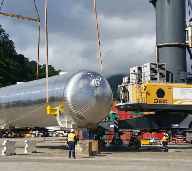 large cylindrical tank being lifted by a crane