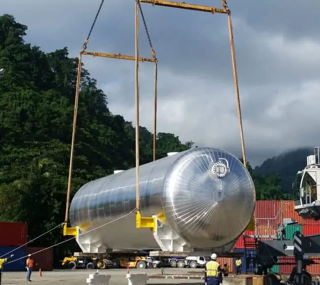 large cylindrical tank being lifted by a crane